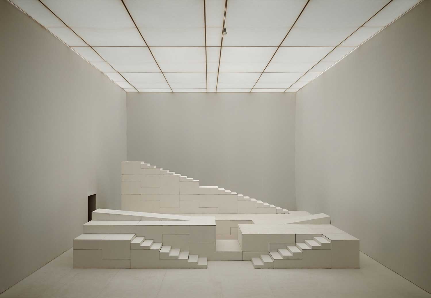 Foto, schwarz-weiß, innen: Mehrere quaderförmige bewegliche Bühnenelemente, darunter zwei Treppen.
